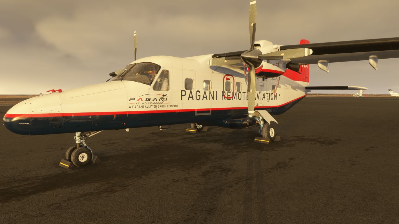 Dornier 228 in PRA livery on the ramp, chocked, under an overcast sky